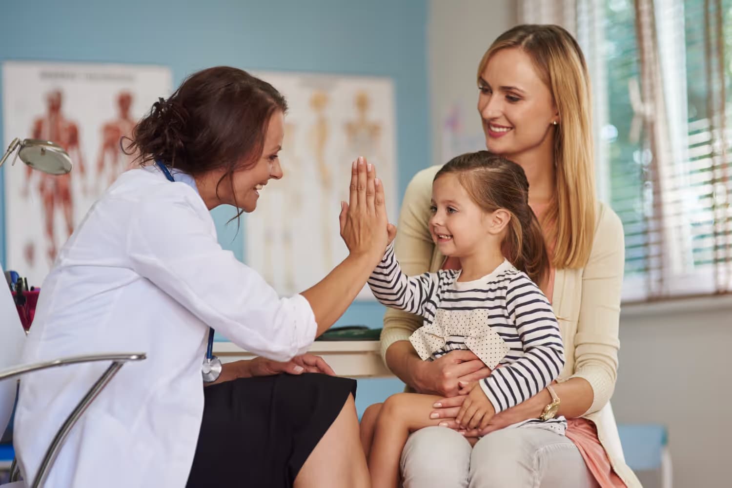 family doctor with parents and child in clinic